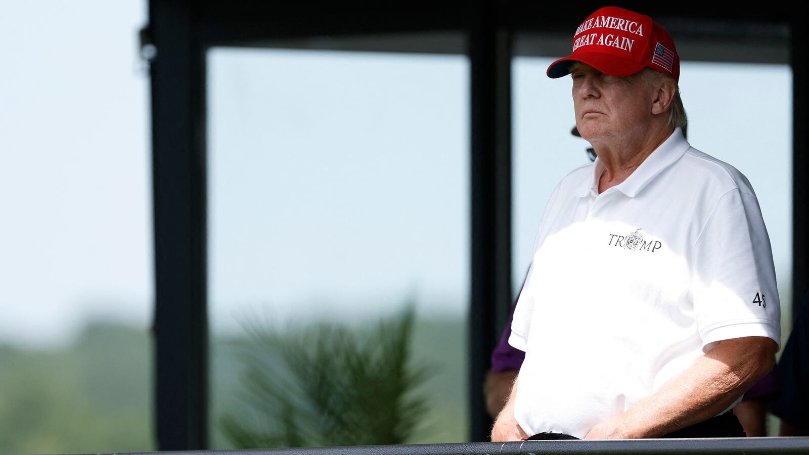Former President Donald Trump looks on from a hospitality suite on the eighteenth green during the second round of LIV Golf Washington, D.C. golf tournament at Trump National.