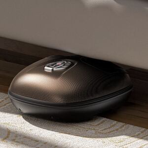 RENPHO Shiatsu Foot Massager stored under a couch on a hardwood floor next to a patterned area rug