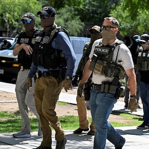 FILE PHOTO: Masked law enforcement officers, including HSI and ICE agents, walk into an immigration court in Phoenix, Arizona, U.S., May 21, 2025.  REUTERS/Caitlin O'Hara/File Photo