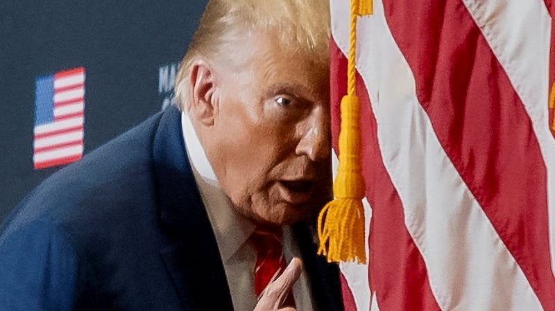 Donald Trump acts confused at to mock Joe Biden during a 2024 campaign event.