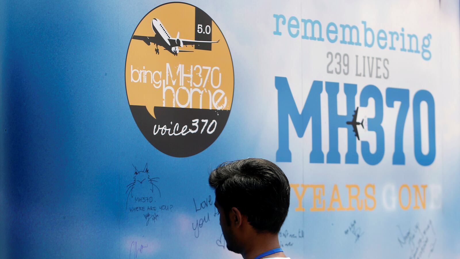 A man writes on a message board for passengers, onboard the missing Malaysia Airlines Flight MH370, during its fifth annual remembrance event in Kuala Lumpur, Malaysia March 3, 2019.