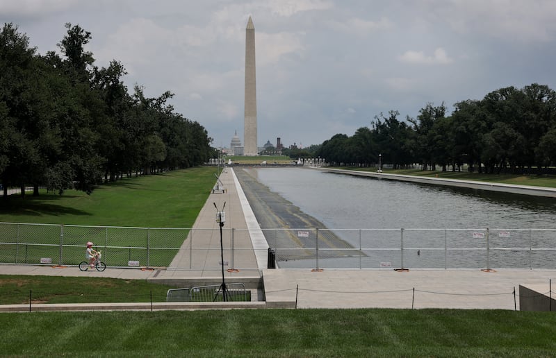 A child rides their bike past the Lincoln Memorial Reflecting Pool as it's drained.