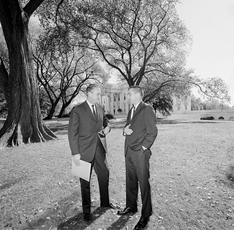 Staff Assistant to the President for Congressional Liaison, Charles U. Daly (right), visits with an unidentified member of Congress. North Lawn, White House, Washington, D.C.