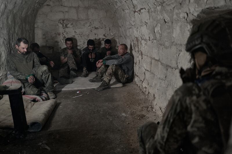 DONETSK REGION, UKRAINE - AUGUST 17: Captured Russian servicemen of the Russian army sit under guard after being taken prisoner by soldiers of Ukraine's 82nd Air Assault Brigade in the area between Dobropillia and Pokrovsk, where Russian forces had recently made a 10-kilometer breakthrough, on August 17, 2025 in Donetsk Region, Ukraine. The prisoners were provided with medical aid, food, water, and cigarettes, as Ukrainian troops stabilized the situation in the sector and continue clearing operations and taking Russian soldiers captive.  (Photo by Vlada Liberova/Libkos/Getty Images)