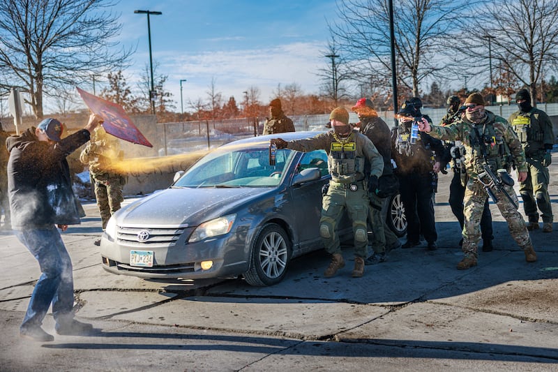 TOPSHOT - Federal agents use pepper spray against a protester holding a sign during an enforcement operation outside the Whipple Building, ICE facility in Minneapolis, Minnesota, on January 11, 2026. A US Immigration and Customs Enforcement (ICE) agent shot and killed 37-year-old Renee Nicole Good on the streets of Minneapolis on January 7, leading to huge protests and outrage from local leaders who rejected White House claims she was a domestic terrorist. (Photo by Kerem YUCEL / AFP via Getty Images)