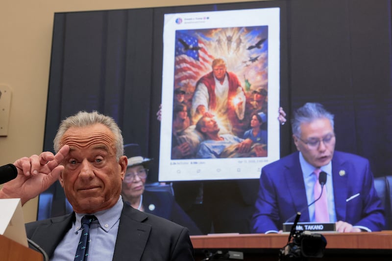 Health and Human Services Secretary Robert F. Kennedy Jr. listens as Rep. Mark Takano presents an AI image posted by President Donald Trump depicting himself as a Jesus-like figure, and questions the president's mental fitness and emotional stability at a hearing on Capitol Hill on April 17, 2026.
