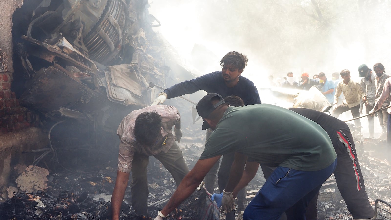 TOPSHOT - Rescue officials work at the site where Air India flight 171 crashed in a residential area near the airport in Ahmedabad on June 12, 2025. The London-bound passenger plane crashed on June 12 in India's western city of Ahmedabad with 242 on board, aviation officials said in what the airline called a "tragic accident". (Photo by Sam PANTHAKY / AFP) (Photo by SAM PANTHAKY/AFP via Getty Images)