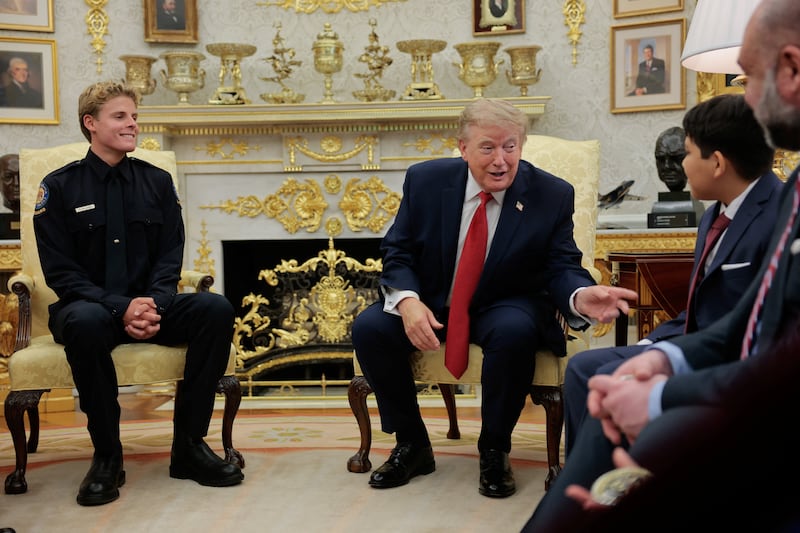 U.S. President Donald Trump hosts 16-year-old lifeguard Ryder Williams, who saved a child off the coast of Santa Cruz, California, last month, and Nathaniel Rai, the child saved by Williams, in the Oval Office at the White House in Washington, D.C., U.S., August 17, 2026. REUTERS/Kylie Cooper