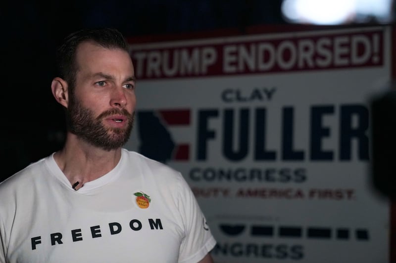 Trump-backed candidate Clay Fuller, with a sign touting the president's endorsement behind him, speaks to members of the media after arriving early to his voting precinct to cast his vote on March 10, 2026 in Lookout Mountain, Georgia.