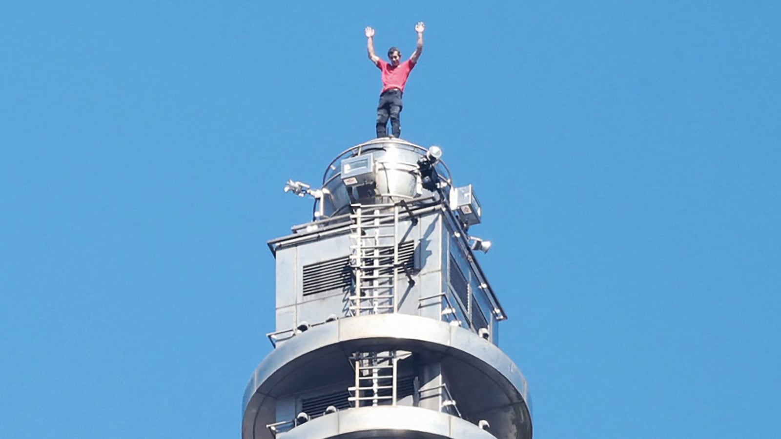 TOPSHOT - US rock climber Alex Honnold raises his arms from the top of the Taipei 101 building after he successfully free soloed the landmark skyscraper without ropes or safety gear in Taipei on January 25, 2026. (Photo by I-HWA CHENG / AFP via Getty Images)