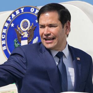 Marco Rubio waves while boarding a plane