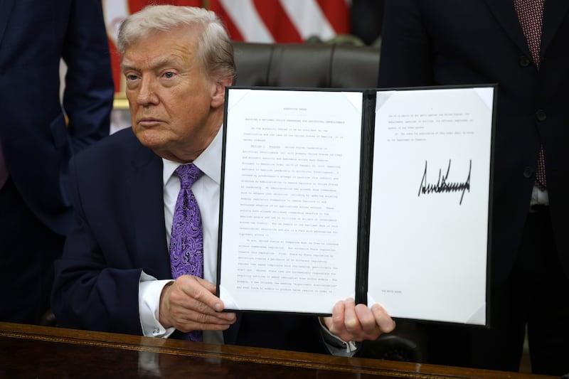 WASHINGTON, DC - DECEMBER 11: U.S. President Donald Trump displays a signed executive order in the Oval Office of the White House on December 11, 2025 in Washington, DC. The executive order curbs states' ability to regulate artificial intelligence, something for which the tech industry has been lobbying.  (Photo by Alex Wong/Getty Images)