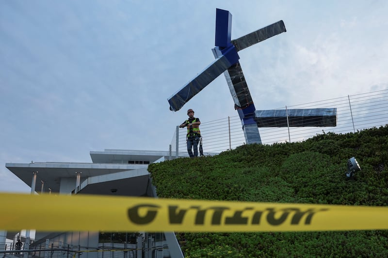 A worker looks on as crews work to remove the sculpture titled "Blue" by artist Joel Shapiro from the grounds of The Kennedy Center for the Performing Arts, after it was targeted for removal by the Trump administration, in Washington, D.C. on September, 2, 2026.