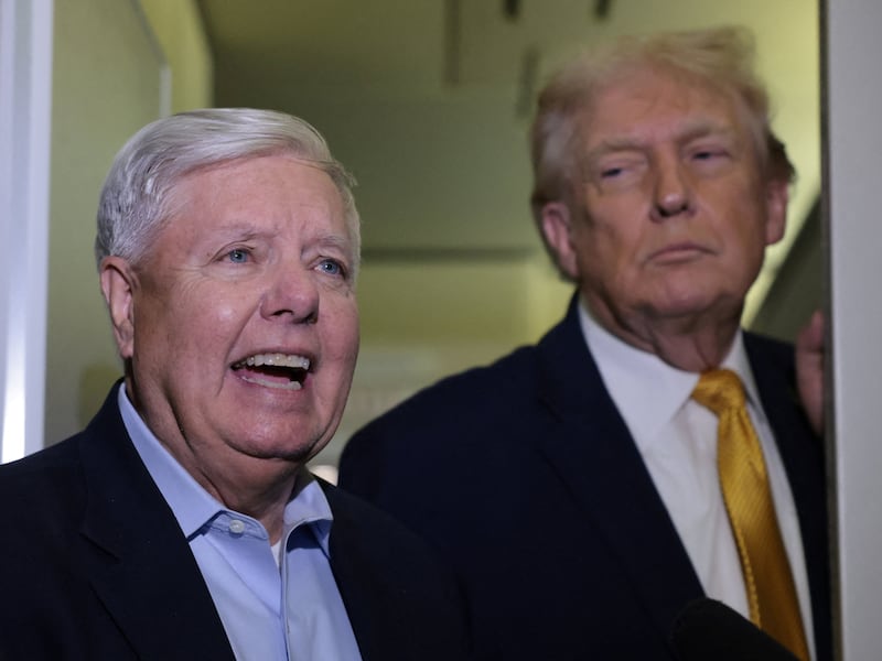 U.S. Senator Lindsey Graham (R-SC) joins President Donald Trump to speak to reporters aboard Air Force One en route from Florida to Joint Base Andrews, Maryland, U.S., January 4, 2026. REUTERS/Jonathan Ernst