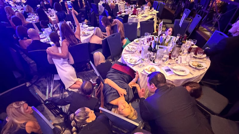 Guests take cover after U.S. President Donald Trump and first lady Melania Trump were rushed out of the White House Correspondents' Association dinner by Secret Service agents after a loud, unidentified noise, in Washington, D.C., U.S. April 25, 2026. Picture taken using a mobile phone.  REUTERS/Evan Vucci