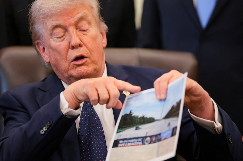U.S. President Donald Trump shows an image as he speaks about renovations at the Lincoln Memorial Reflecting Pool during a healthcare affordability event in the Oval Office at the White House in Washington, D.C., U.S., April 23, 2026. REUTERS/Kylie Cooper