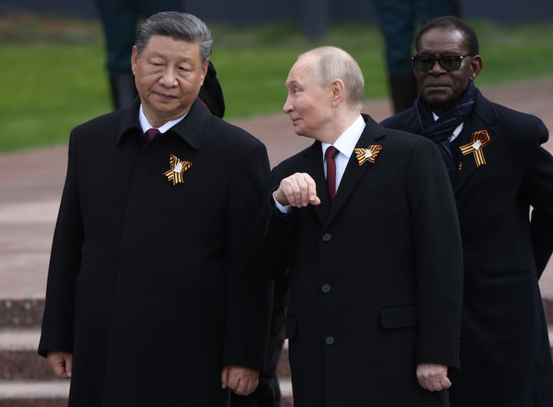MOSCOW, RUSSIA - MAY 9 (RUSSIA OUT) Russian President Vladimir Putin (C) talks to Chinese President Xi Jinping (L) as President of Equatorial Guinea Teodoro Obiang Nguema Mbasogo (R) looks on during the wreath laying ceremony to the Unknown Soldies' Tomb, marking the 80th anniversary of the victory over Nazi's Germany, May 9, 2025 in Moscow, Russia. President Putin has welcomed Chinese Leader Xi Jinping in Moscow for a four-day visit centred aroind Russia's 'Victory Day' celebrations, commemorated the end of the World War II. The trip marsk Xi's eleventh trip to Russia since becoming president. (Photo by Contributor/Getty Images)