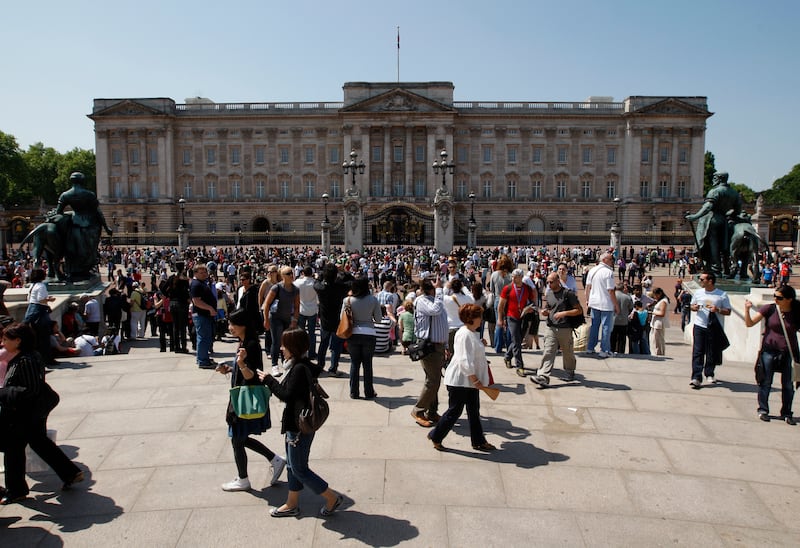 Tourists stand in front of Buckingham Palace in London, May 24, 2009.