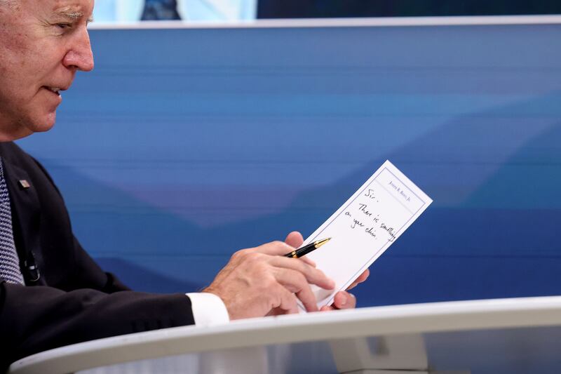 U.S. President Joe Biden holds up a note saying "Sir, there is something on your chin" during a virtual meeting with U.S. Vice President Kamala Harris and  west coast Governors