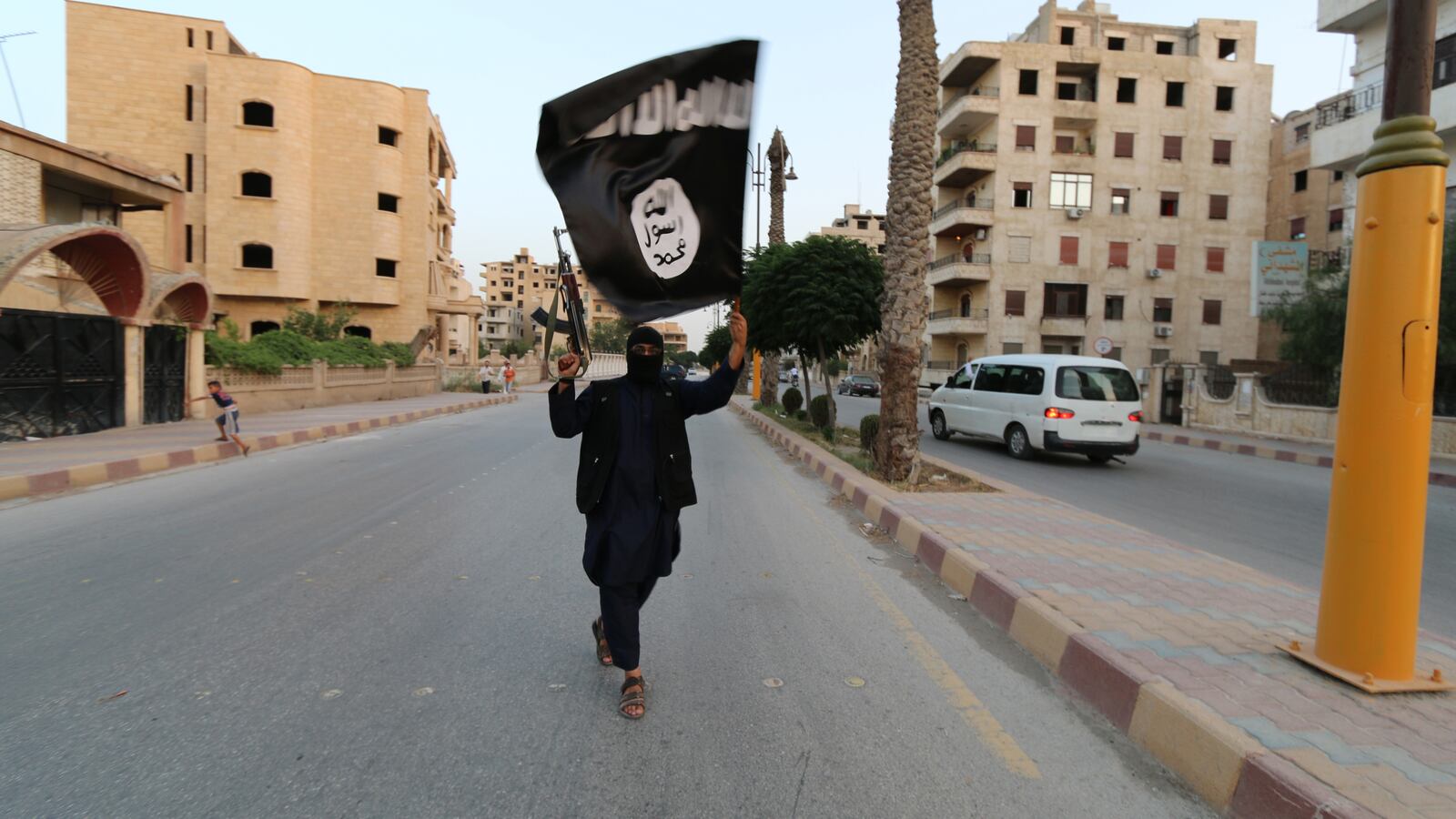 A member loyal to the Islamic State in Iraq and the Levant (ISIL) waves an ISIL flag in Raqqa June 29, 2014.