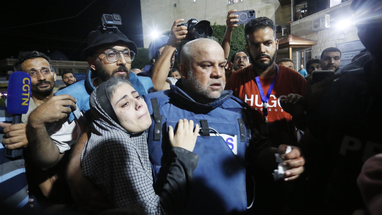 Al Jazeera reporter Wael al-Dahdouh carries his injured son from an ambulance to hospital in Gaza City.
