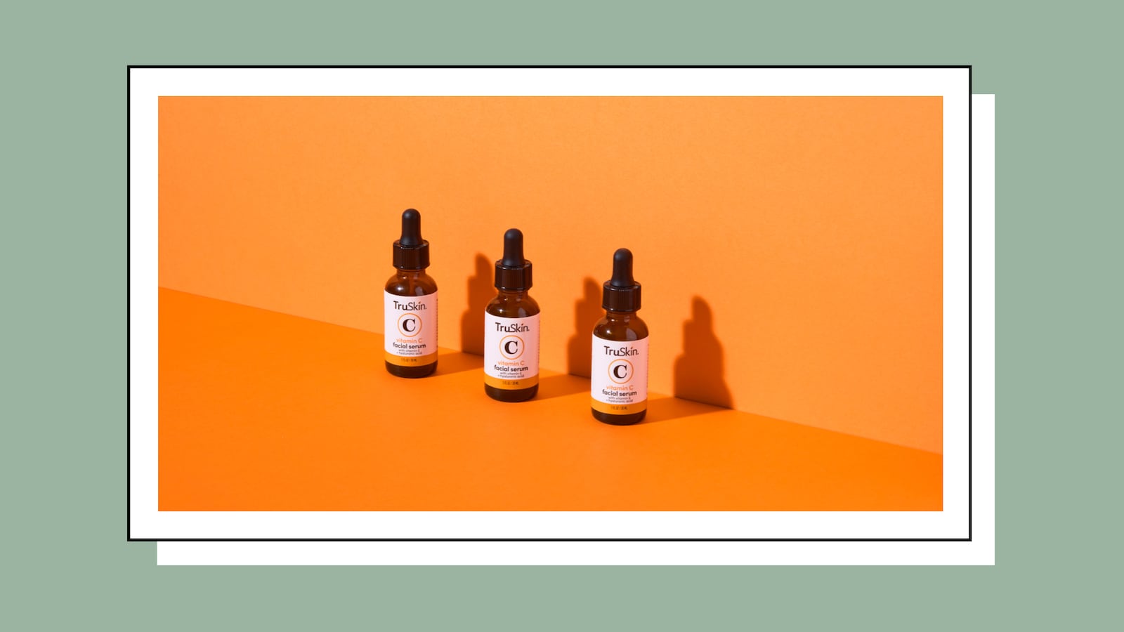 TruSkin vitamin C facial serum bottles arranged on an orange background, showcasing a three-step skincare routine for brightening and anti-aging
