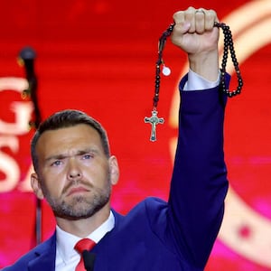 Jack Posobiec holds up a rosary as he speaks during a memorial service for slain conservative commentator Charlie Kirk at State Farm Stadium, Arizona, U.S., September 21, 2025.