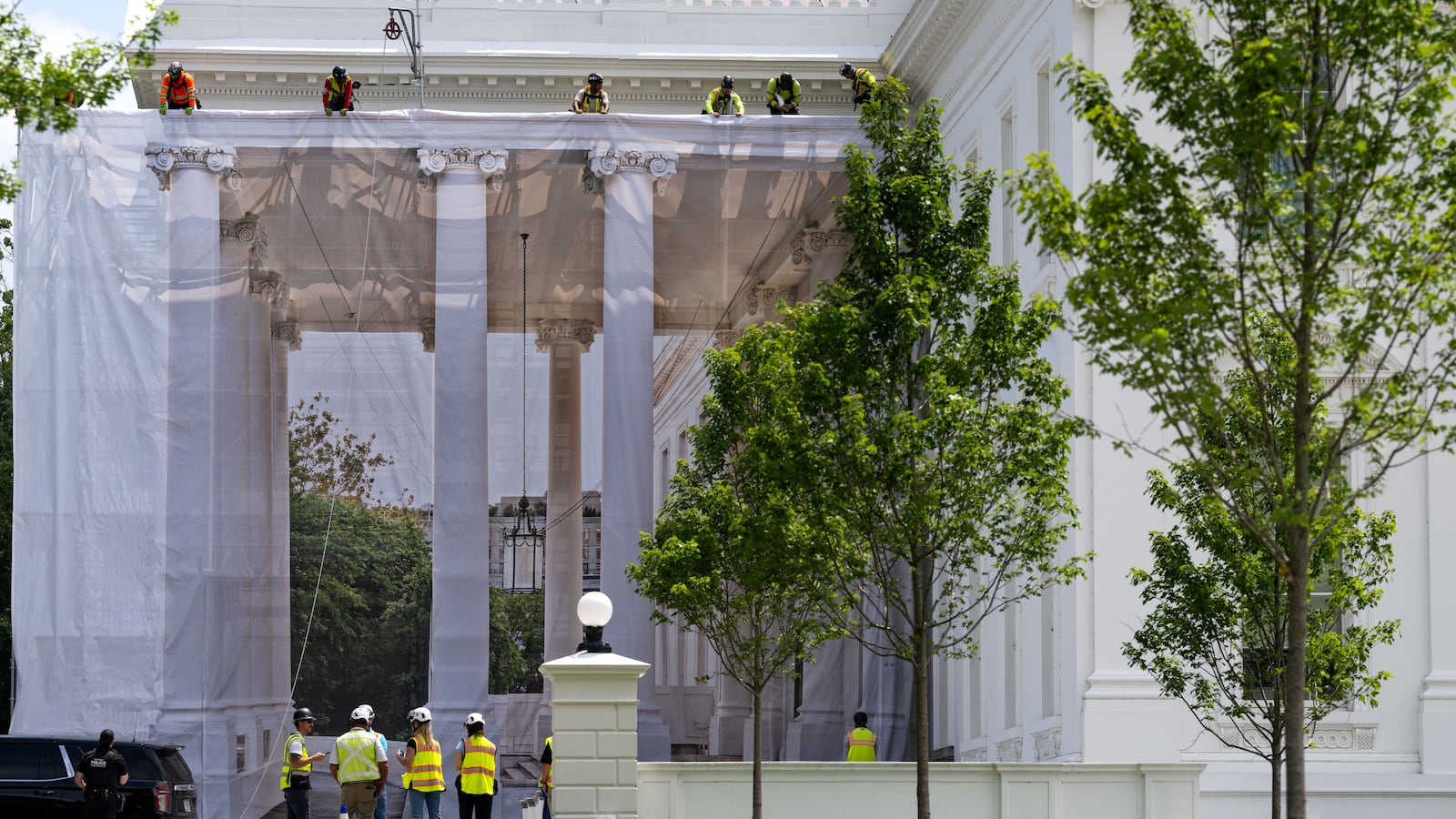 Workers place a protective cover over scaffolding surrounding the North Portico of the White House in Washington, DC on July 9, 2026.