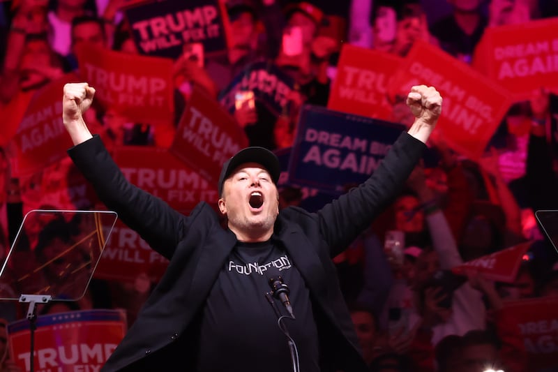 Elon Musk raises his hands as he takes the stage during a campaign rally for Donald Trump, at Madison Square Garden on October 27, 2024 in New York City.
