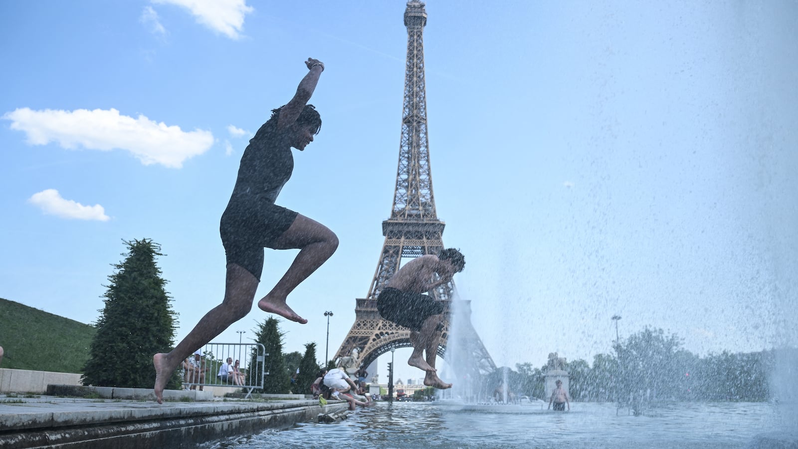 People jump in the water near the Eiffel Tower
