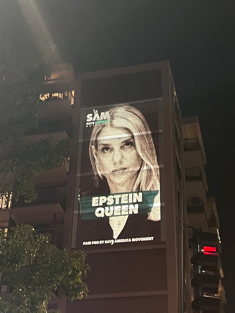 Projection of Pam Bondi with "Epstein Queen" superimposed on Washington DC building.