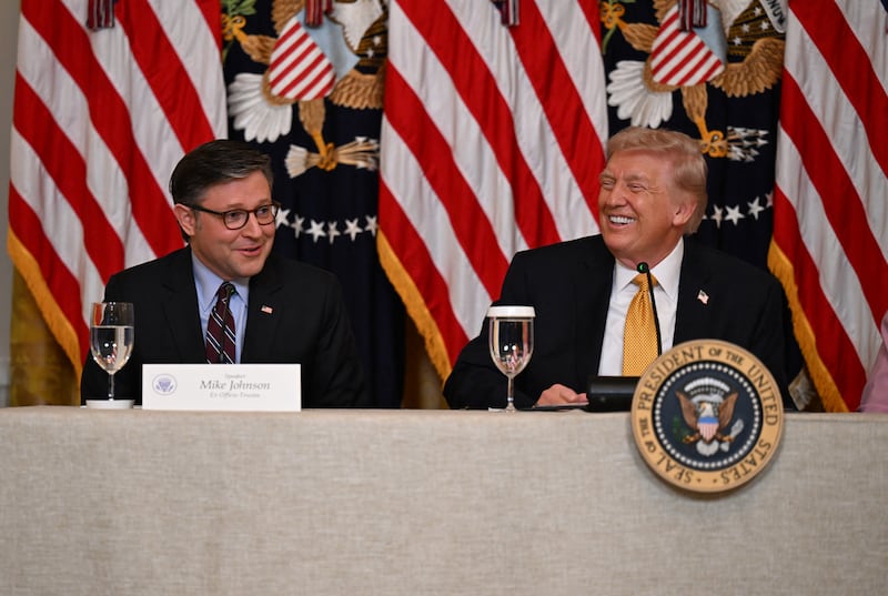 President Donald Trump smiles as House Speaker Mike Johnson speaks about a GOP lawmaker's terminal diagnosis during a lunch with the Kennedy Center Board members at the White House in Washington, DC, on March 16, 2026.