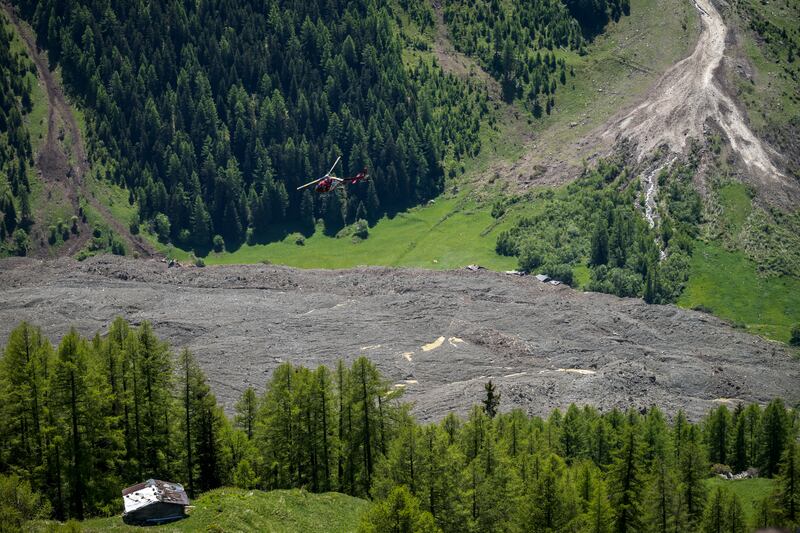 A helicopter flies above the landslide area in the Alps' Lotschental valley after part of the huge Birch Glacier collapsed on the day before and destroyed the small village of Blatten in the Swiss Alps, in Wiler on May 29, 2025.