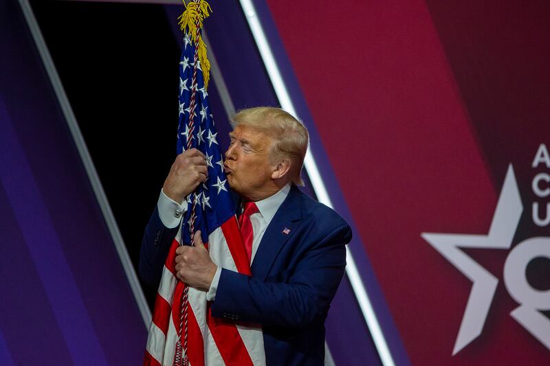 NATIONAL HARBOR, MARYLAND - FEBRUARY 29: President Donald Trump kisses the flag of the United States of America at the annual Conservative Political Action Conference (CPAC) at Gaylord National Resort & Convention Center February 29, 2020 in National Harbor, Maryland. Conservatives gather at the annual event to discuss their agenda.  (Photo by Tasos Katopodis/Getty Images)