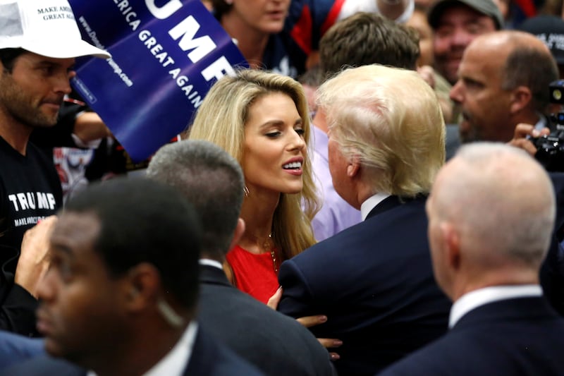 Republican U.S. presidential candidate Donald Trump (2nd R) embraces former Miss California USA Carrie Prejean (C) after a rally with supporters in San Diego, California, U.S. May 27, 2016. Also pictured is Prejean's husband, former NFL quarterback Kyle Boller (L). REUTERS/Jonathan Ernst