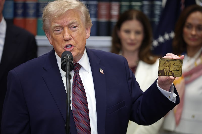 President Donald Trump holds a "Trump Gold Card" during an event in the Roosevelt Room of the White House December 19, 2025 in Washington, DC.