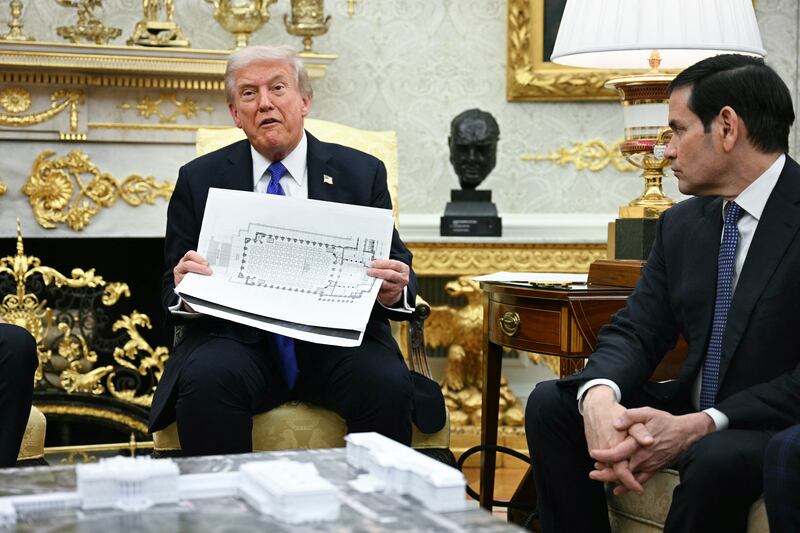 US President Donald Trump shows the floor plan of his planned ballroom as he meets with NATO Secretary General Mark Rutte in the Oval Office of the White House in Washington, DC, on October 22, 2025.