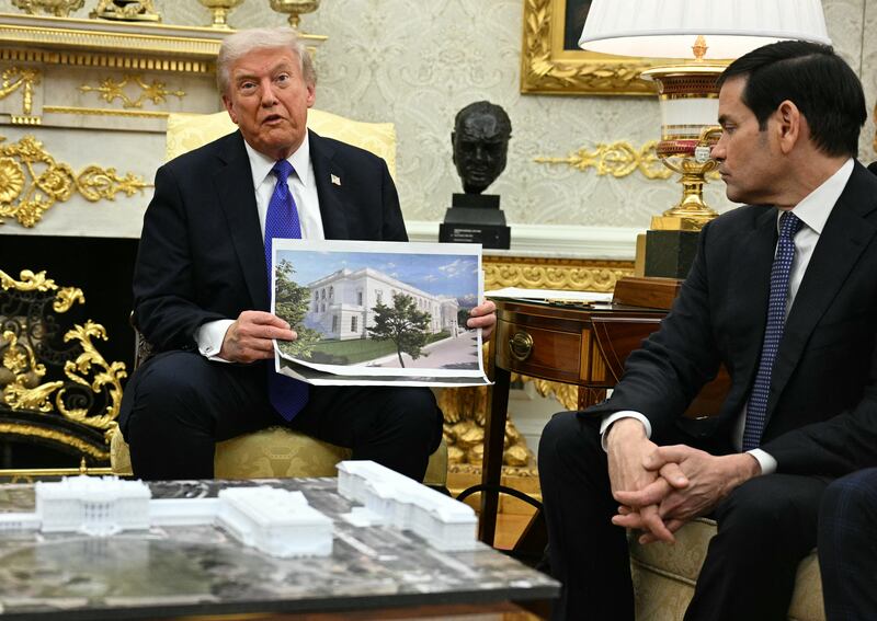 US President Donald Trump shows a rendition of the East Wing of the White House currently being demolished to build a ballroom as he meets with NATO Secretary General Mark Rutte in the Oval Office of the White House in Washington, DC, on October 22, 2025. (Photo by Jim WATSON / AFP) (Photo by JIM WATSON/AFP via Getty Images)