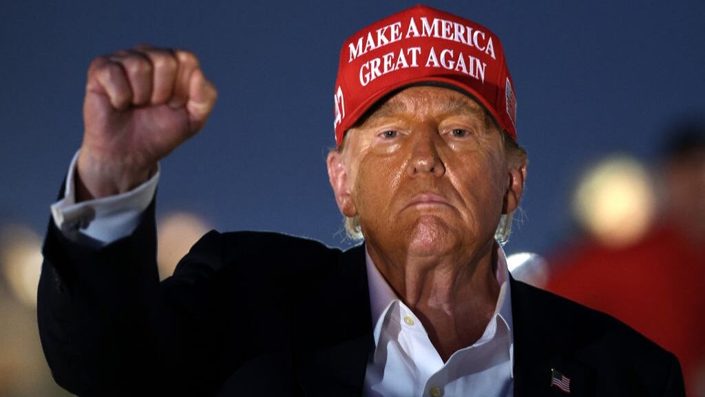 Donald Trump raises his fist as he looks on during the NASCAR Cup Series Coca-Cola 600 at Charlotte Motor Speedway on May 26, 2024.
