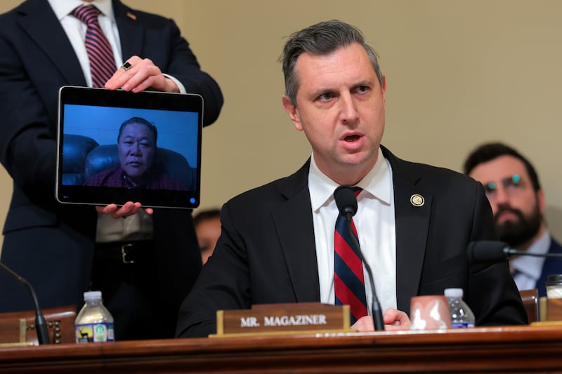 Democratic Rep. Seth Magaziner holds a tablet connected to a Zoom call with Army veteran and green card holder Sae Joon Park, who was was taken into custody and self-deported to South Korea, as he questions Secretary of Homeland Security Kristi Noem during a House Committee on Homeland Security hearing on December 11, 2025.