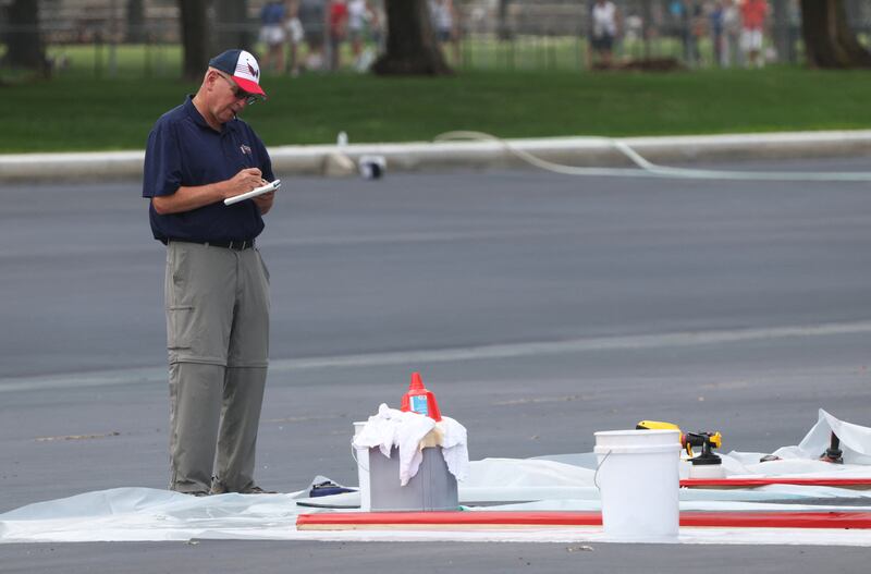 A worker makes notes while standing over a patch of the Lincoln Memorial Reflecting Pool as work continues to correct the botched repair project in Washington, D.C., U.S., August 18, 2026. REUTERS/Kevin Lamarque
