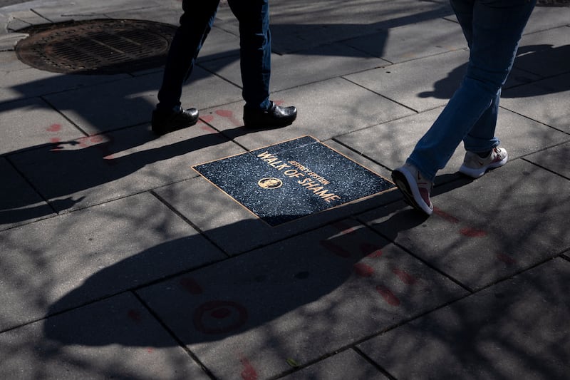 People walk along the "Jeffrey Epstein Walk of Shame", which features prominent names that appear in the Epstein files, near the White House on March 1, 2026, in Washington, DC.