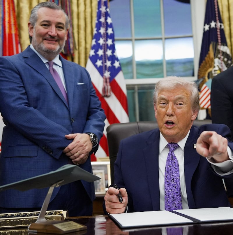 U.S. President Donald Trump points his finger as he signs an executive order on AI next to U.S. Senate Commerce Committee Chairman Ted Cruz (R-TX) and U.S. Commerce Secretary Howard Lutnick, in the Oval Office at the White House in Washington, D.C., U.S. December 11, 2025. REUTERS/Al Drago