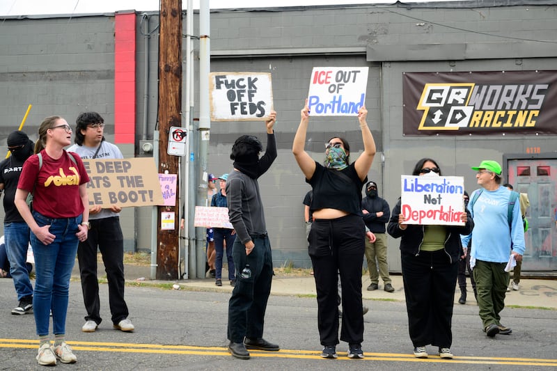 Protesters wave signs outside of the U.S. Immigration and Customs Enforcement building on September 28, 2025 in Portland, Oregon.