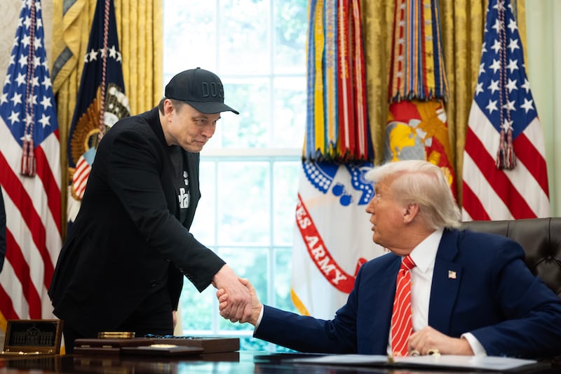Elon Musk shakes the hand of President Trump