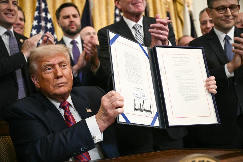 US President Donald Trump displays the GENIUS Act (Guiding and Establishing National Innovation for US Stablecoins Act), which codifies the use of stablecoins -- cryptocurrencies pegged to stable assets like the US dollar or US bonds -- after signing it in the East Room of the White House in Washington, DC, on July 18, 2025. (Photo by Brendan SMIALOWSKI / AFP) (Photo by BRENDAN SMIALOWSKI/AFP via Getty Images)