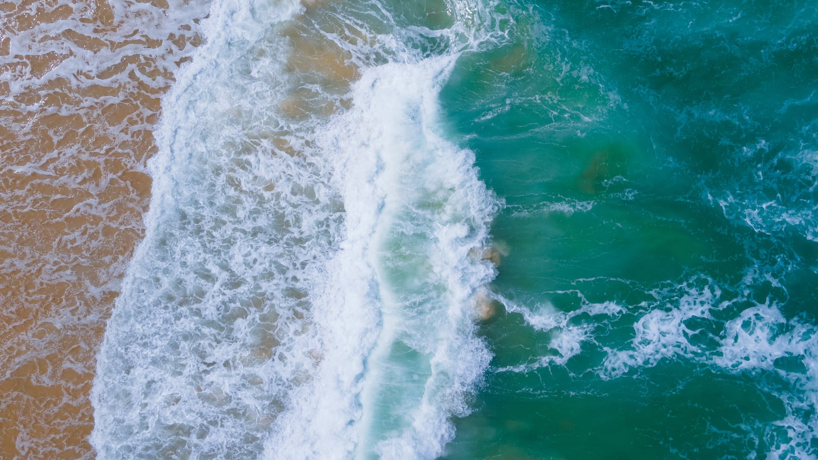 Nature of Aerial view Top-down Beach sand and seawater wave in sunset time. Tropical Sea Andaman Sea