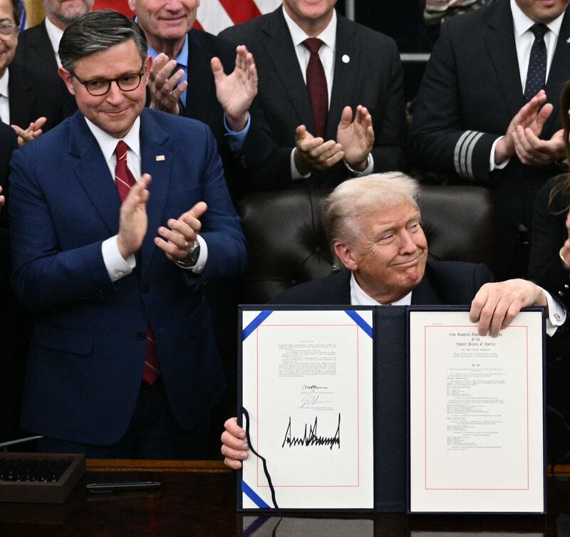 US President Donald Trump (C) shows the signed bill package to re-open the federal government as the Speaker of the House Mike Johnson (L) and other Republican leaders applaud
