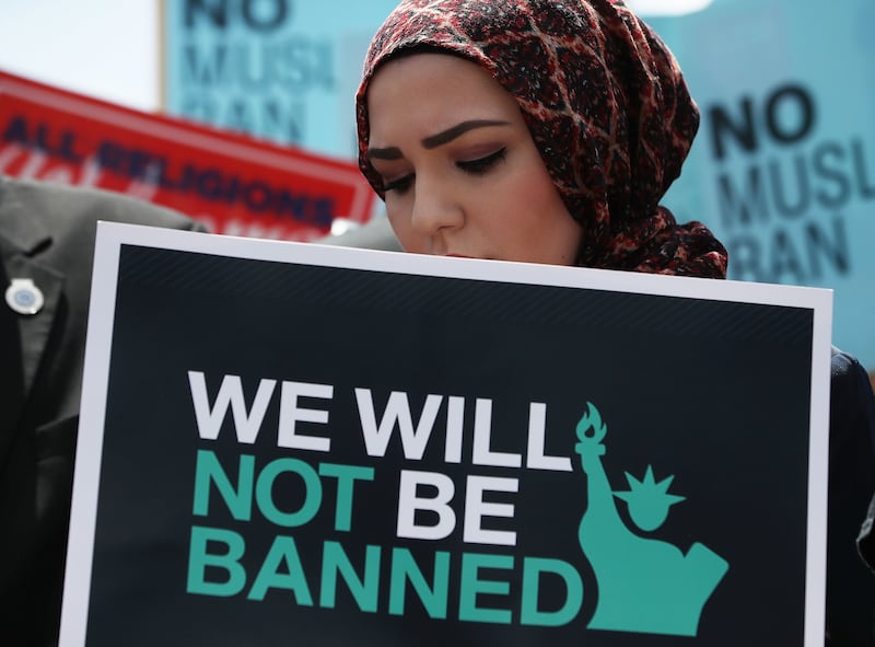 A women protests against U.S. President Trump's Muslim travel ban as protesters gather outside the U.S. Supreme Court in 2018.
