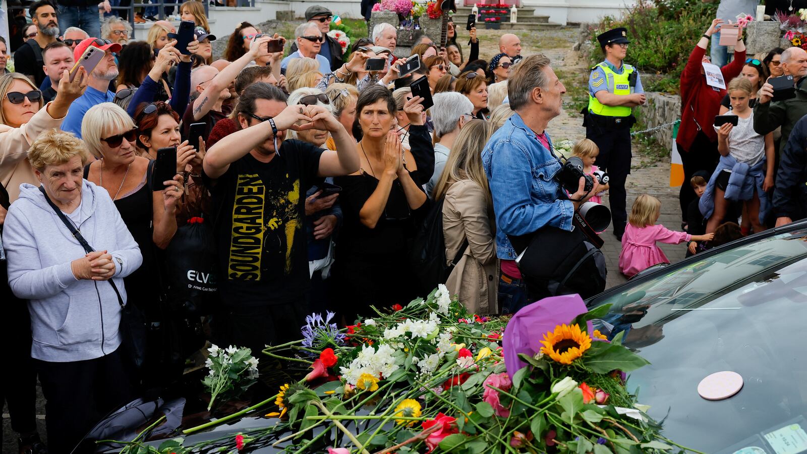 A hearse carrying the coffin of late Irish singer Sinead O'Connor passes outside her former home during her funeral procession as fans line the street to say their last goodbye to her, in Bray, Ireland.